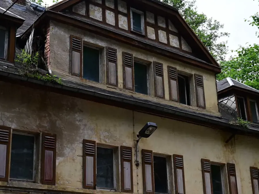 Fassadendetail des Hauptgebäudes mit Fensterläden und schadhaftem Putz