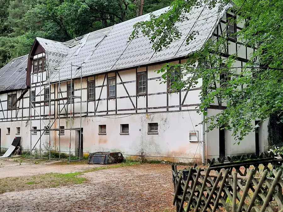 Fachwerk-Nebengebäude mit notgesichertem Dach und stehendem Gerüst